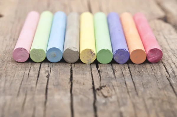 Tiza de colores en la vieja mesa de madera — Foto de Stock