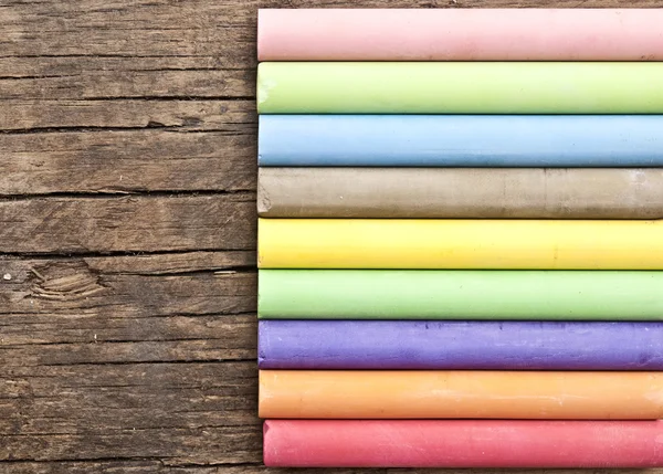 Colorful chalks on old wooden table — Stock Photo, Image