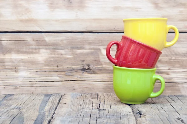 Tazas de colores sobre el fondo de madera —  Fotos de Stock