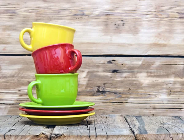 Copos de café coloridos na mesa de madeira — Fotografia de Stock