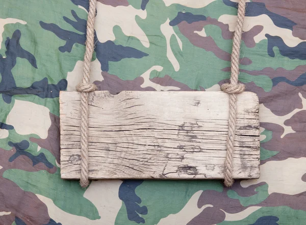 Close up of an empty wooden sign hanging on a rope on military f — Stock Photo, Image