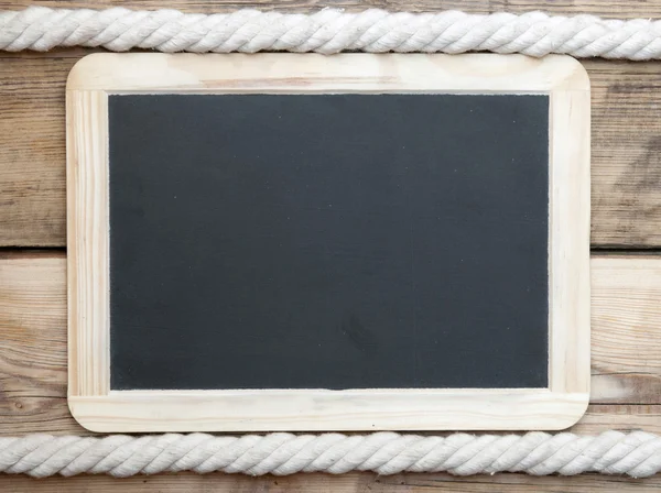 Černá deska na dřevěných prken s pozadím lano — Stock fotografie