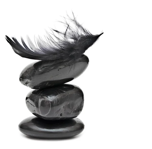 Balance de plumes sur pile de pierres noires - harmonie ou équilibr — Photo