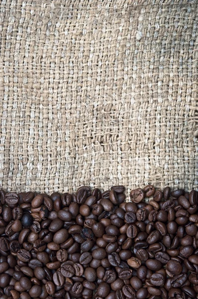 Kaffebönor på burlap bakgrund — Stockfoto