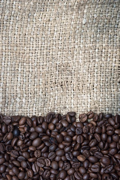 Coffee beans on burlap background — Stock Photo, Image