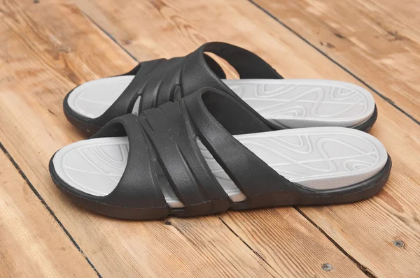 Black flip flops on wooden deck. summer background — Stock Photo, Image