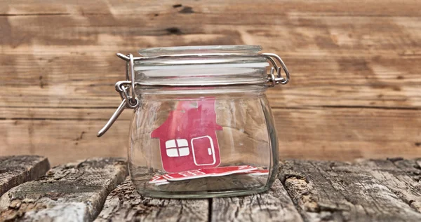 Shape home sign in a glass jar on wooden table — Stockfoto