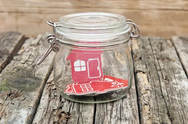 Shape home sign in a glass jar on wooden table — Zdjęcie stockowe