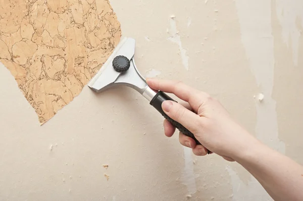 Hand removing wallpaper from wall — Stock Photo, Image
