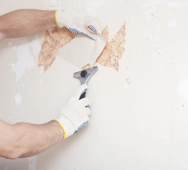 Hand removing wallpaper from wall — Stock Photo, Image