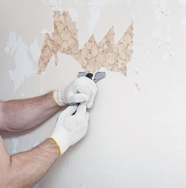 Hand removing wallpaper from wall — Stock Photo, Image