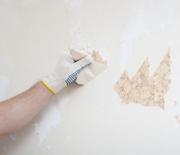 Mão removendo papel de parede da parede — Fotografia de Stock