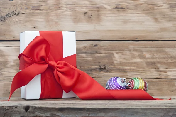 Vita lådor, rött band och christmas ball på trä bakgrund — Stockfoto