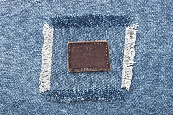 Lege lederen jeans label naaide op een blauwe spijkerbroek. kan worden gebruikt als — Stockfoto