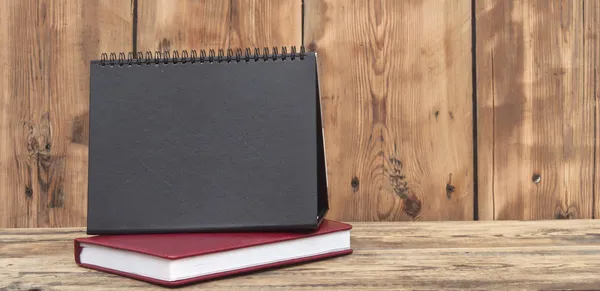 Schreibtischkalender mit rotem Ledernotizbuch auf Holztisch — Stockfoto