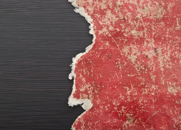 Loch in rotem Papier auf schwarzem Hintergrund gerissen. Kopierraum — Stockfoto
