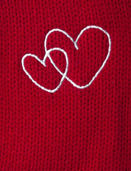 Two white heart embroidered handmade on red canvas — Stock Photo, Image