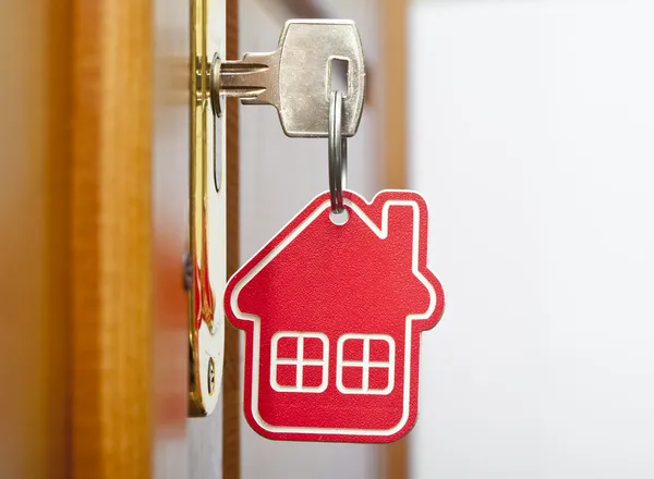 Símbolo da casa e enfiar a chave na fechadura — Fotografia de Stock