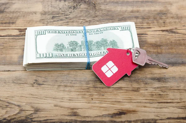 Klíče od domu nad sto dolarové bankovky proti dřevěným zpět — Stock fotografie