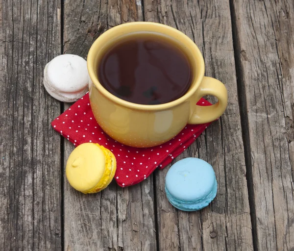 Macaron colorato con una tazza di caffè su vecchio sfondo di legno — Foto Stock