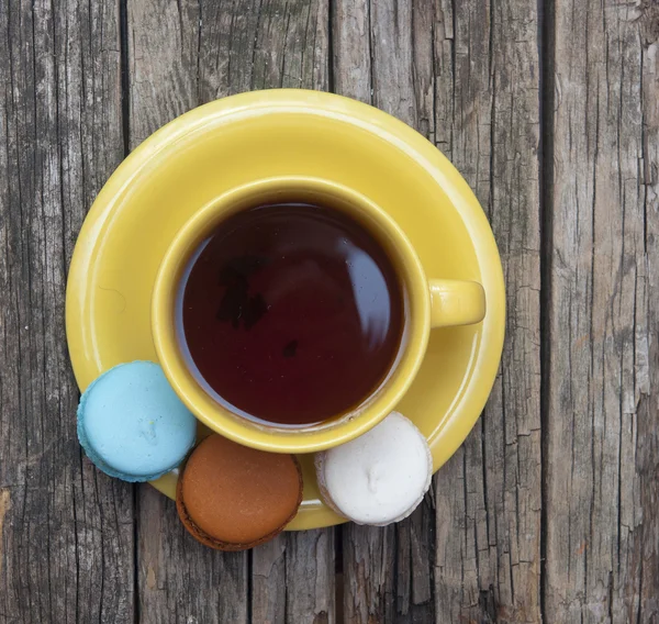 Färgglada mandelkaka med en kopp kaffe på gamla trä bakgrund — Stockfoto
