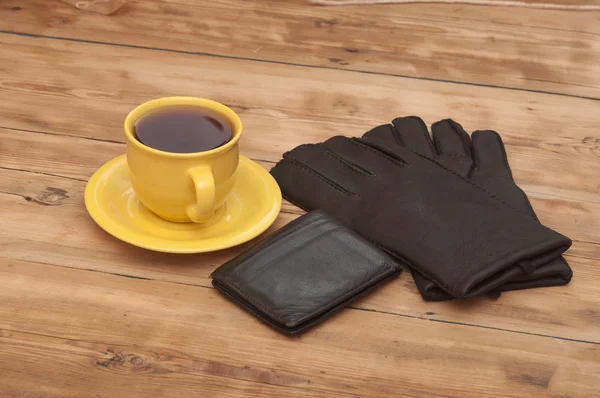 Mens wallet, gloves and coffee cup on wooden background — Stock Photo, Image