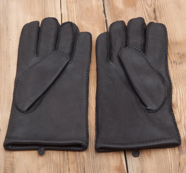 Pair of men's black leather gloves on wooden table top — Stock Photo, Image