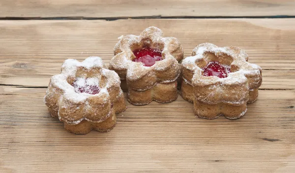 Bloemen vorm cookies cover met poeder suiker op een houten tafel — Stockfoto