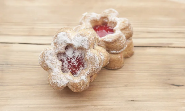 Bloemen vorm cookies cover met poeder suiker op een houten tafel — Stockfoto