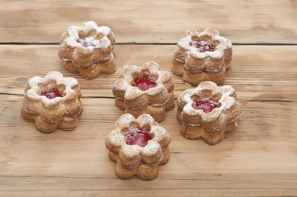 Bloemen vorm cookies cover met poeder suiker op een houten tafel — Stockfoto