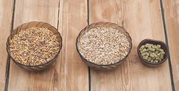 Beer ingredients, hops and malt on wooden table top — Stock Photo, Image