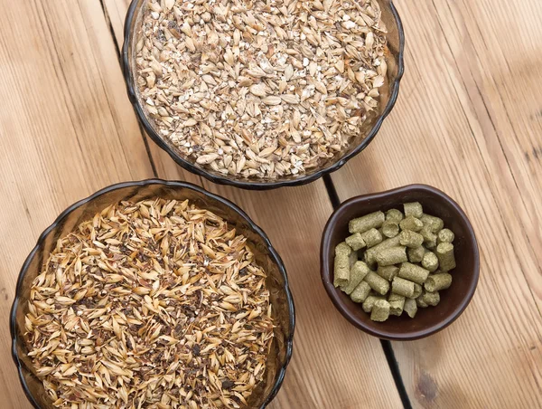 Beer ingredients, hops and malt on wooden table top — Stock Photo, Image