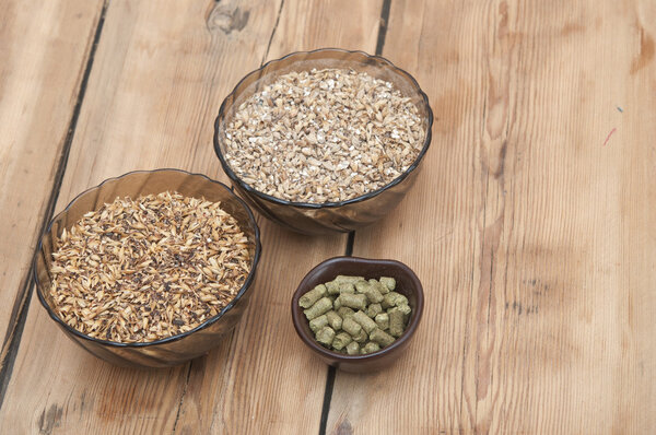 beer ingredients, hops and malt on wooden table top