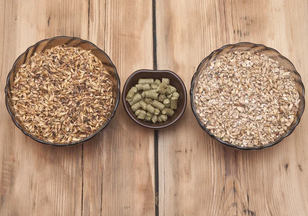 Beer ingredients, hops and malt on wooden table top — Stock Photo, Image