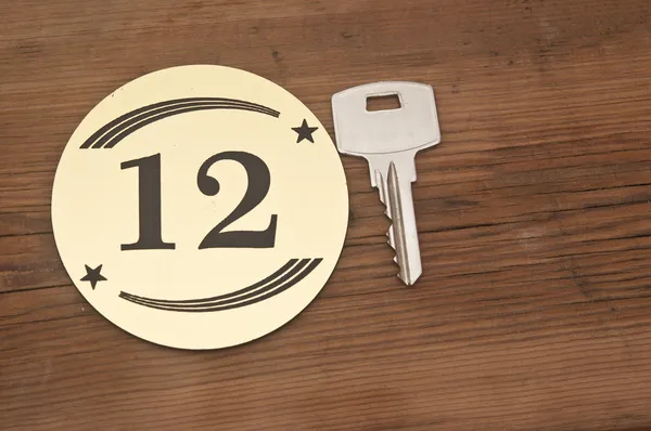 Hotelsuite Schlüssel mit Zimmernummer 12 auf Holztisch — Stockfoto