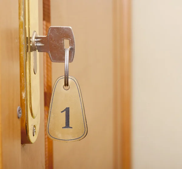 Key in keyhole with numbered label — Stock Photo, Image