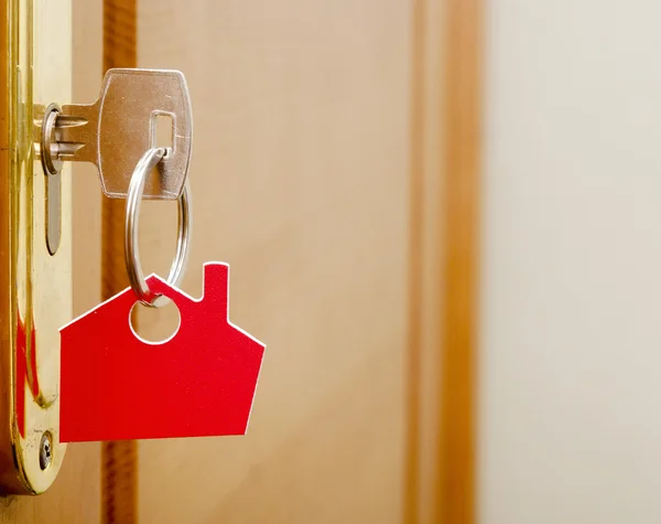 Símbolo da casa e enfiar a chave na fechadura — Fotografia de Stock