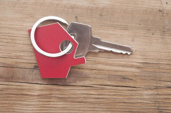 Symbole de la maison avec clé argent sur fond bois vintage — Photo