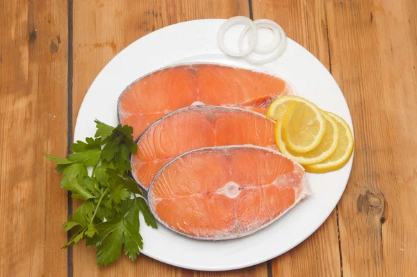 Dish for baking with slices of salmon over wooden table — Stock Photo, Image