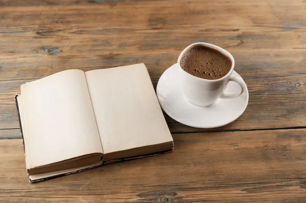木製のテーブルの上にコーヒーのカップの横に空白のページで本を開きます テキストやモックアップを追加する準備ができて — ストック写真
