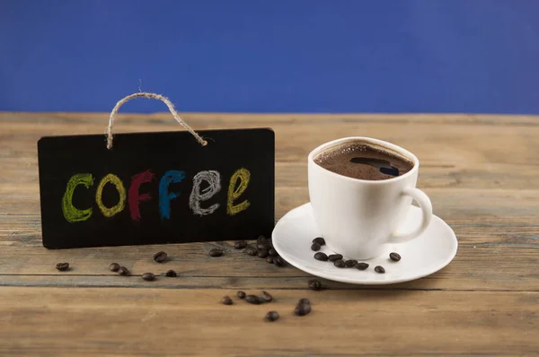 色鮮やかなアルファベットで書かれた碑文 コーヒー とコーヒーと黒板の白いセラミックカップ コーヒーブレイク朝の目覚めのコンセプト — ストック写真
