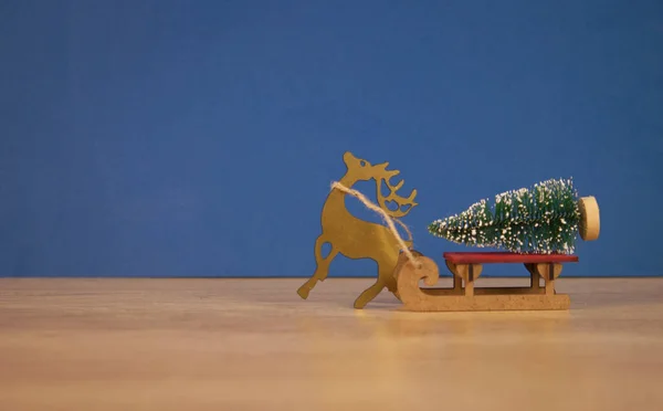 濃い青の背景に装飾的なモミの木と木製のそり クリスマス休暇クリスマスと新年のコンセプト — ストック写真