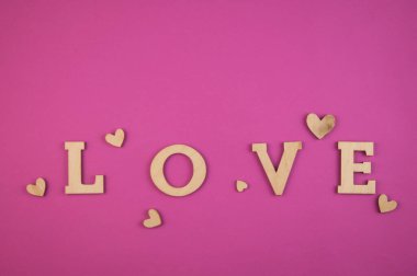 Aşk kelimesi, pembe renkli arka planda küçük kalpler. Sevgililer Günü 'nün en iyi manzarası. Kopyalama alanı.