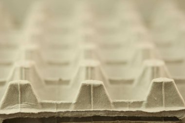 Boş yumurta tepsisi dokusu. Tavuk yumurtaları için geniş bir karton konteynır arka planı. Kırılgan tavuk yumurtaları için tekrar eden desenli biyolojik çözünebilir kağıt ambalajlar. Tam çerçeve.