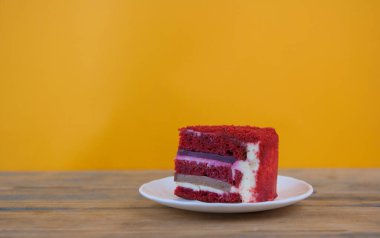 Kutlama pastası. Pastanın bir kısmı. Tahta bir masanın üzerinde bir parça kek yatıyor..