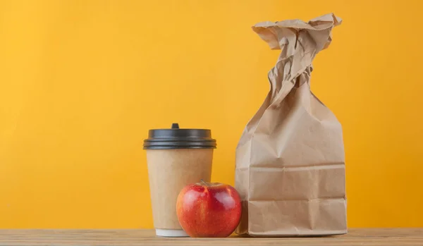 苹果和午餐袋的木制桌子背景 — 图库照片