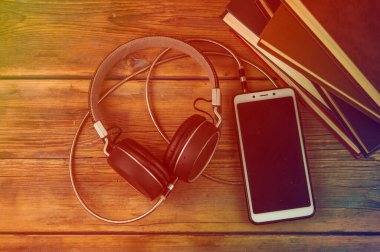 Audiobooks kitap ve kulaklıkları ahşap masada siyah. Üst Manzara. Ton halinde. Ses kitapları dinleme kavramı.
