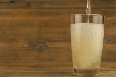 Tahta masadaki cam bardakta limonata.