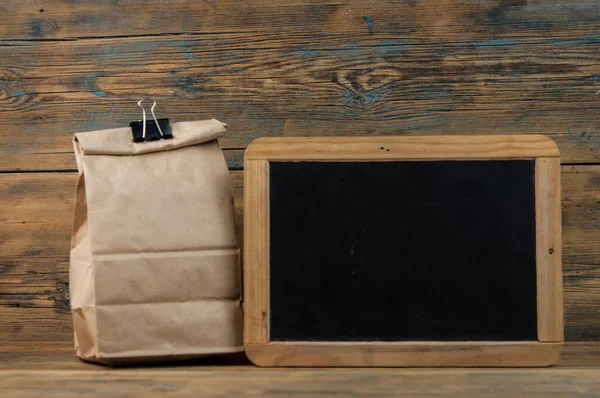 Bolsa Almuerzo Escolar Con Pizarra Blanco Sobre Fondo Madera —  Fotos de Stock