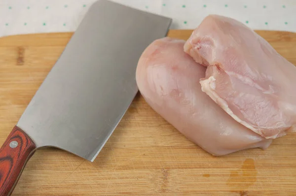 ミートカッターナイフでまな板に生の鶏の肉 — ストック写真